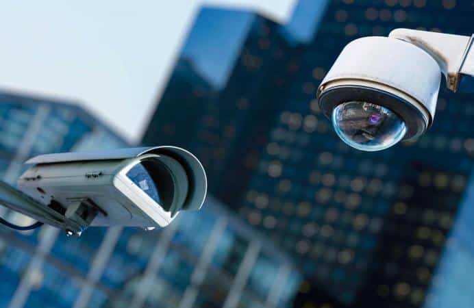 Imagen que representa la solución CCTV implementada por Total Redes con dos cámaras de seguridad con edificios de fondo.