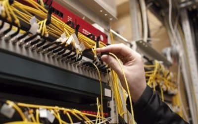 Imagen que muestra un acercamiento de un ingeniero de fibra óptica conectando un cable amarillo de fibra óptica.